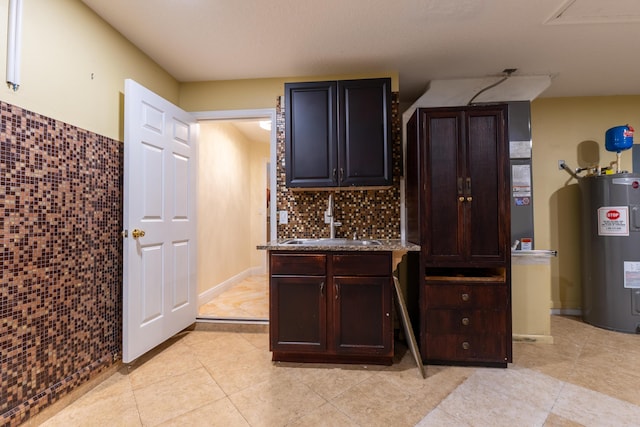 2853 SE Melaleuca Blvd, Port Saint Lucie, FL 34952 - kitchen featuring electric water heater, backsplash, dark brown cabinetry, and light tile patterned flooring