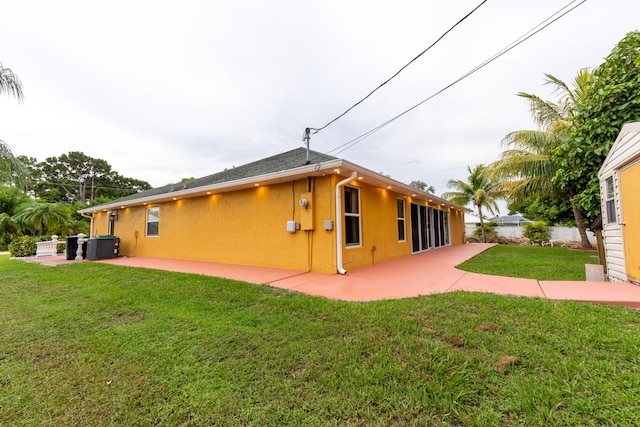 2853 SE Melaleuca Blvd, Port Saint Lucie, FL 34952 - view of home's exterior with stucco siding, a patio area, and a lawn