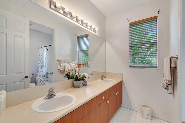 116 Ibisca Ter, Royal Palm Beach, FL 33411 - full bathroom with double vanity, toilet, a shower with shower curtain, tile patterned flooring, and baseboards