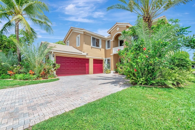 116 Ibisca Ter, Royal Palm Beach, FL 33411 - mediterranean / spanish home with stucco siding, decorative driveway, a tile roof, a garage, and a front lawn