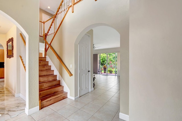 116 Ibisca Ter, Royal Palm Beach, FL 33411 - stairway featuring ceiling fan, baseboards, a towering ceiling, and arched walkways