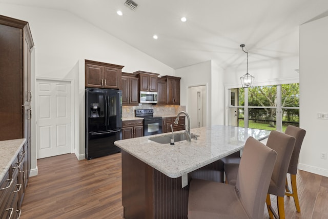 6342 120th Ave N, The Acreage, FL 33412 - kitchen with black appliances, a sink, lofted ceiling, tasteful backsplash, and dark brown cabinets