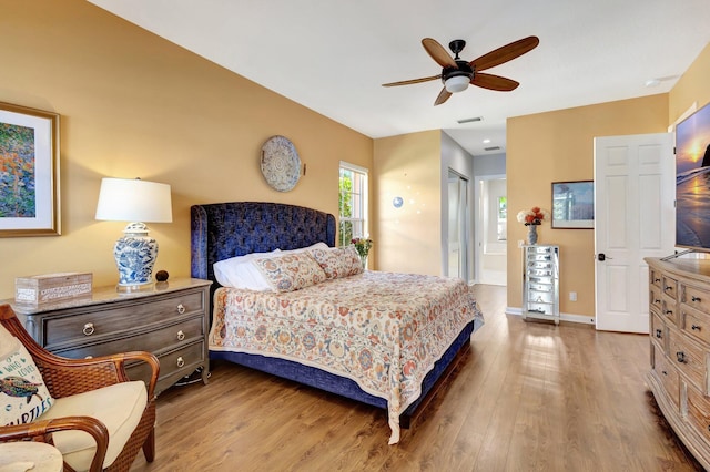 2211 Vero Beach Ln, West Palm Beach, FL 33411 - bedroom featuring wood finished floors, ensuite bath, a ceiling fan, and baseboards