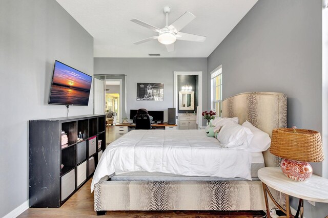 2211 Vero Beach Ln, West Palm Beach, FL 33411 - bedroom featuring wood finished floors, connected bathroom, baseboards, and a ceiling fan