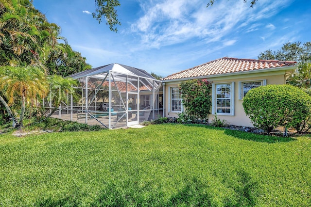 2211 Vero Beach Ln, West Palm Beach, FL 33411 - rear view of house with a tile roof, a lawn, stucco siding, a patio area, and an outdoor pool