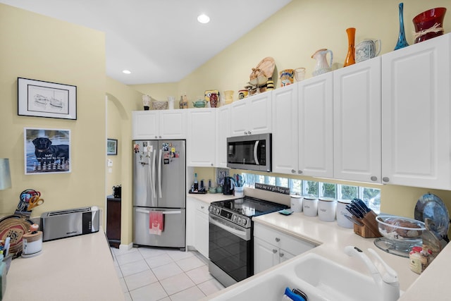 kitchen with stainless steel appliances, white cabinetry, light countertops, and recessed lighting
