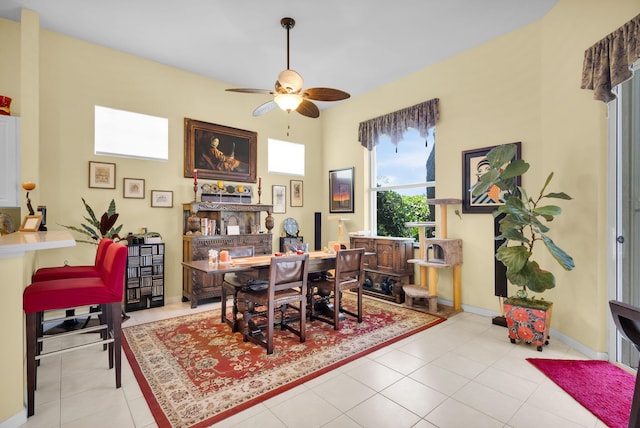 tiled dining area featuring ceiling fan and baseboards