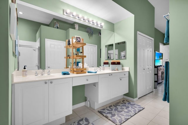 full bathroom with tile patterned flooring, double vanity, an enclosed shower, and baseboards
