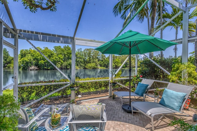 sunroom / solarium with a water view, view of scattered trees, and healthy amount of natural light