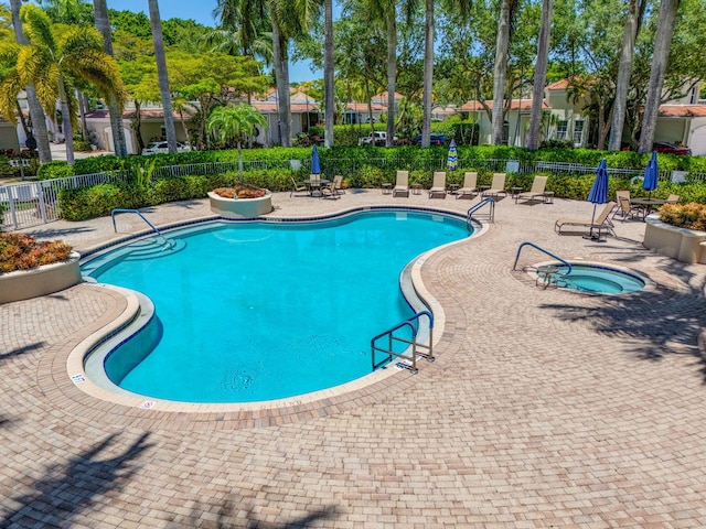community pool with fence, a patio area, and a community hot tub