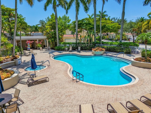 community pool featuring fence and a patio area