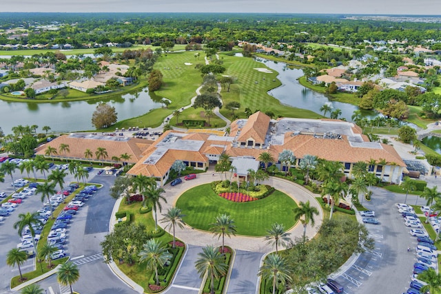 aerial view of property's location featuring a nearby body of water, nearby suburban area, and a golf club