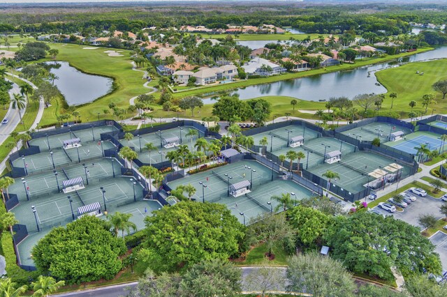 aerial view of property and surrounding area with a local golf course, a nearby body of water, and nearby suburban area