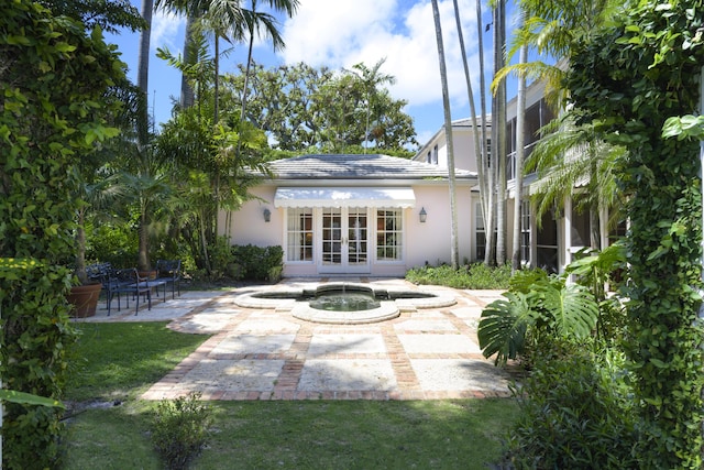 218 El Brillo Way, Palm Beach, FL 33480 - rear view of property featuring french doors, stucco siding, a patio, and an in-ground hot tub