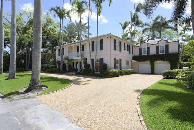 218 El Brillo Way, Palm Beach, FL 33480 - view of front of home with curved driveway, stucco siding, a front yard, an attached garage, and a balcony