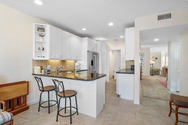 5900 Old Ocean Blvd Unit C6, Ocean Ridge, FL 33435 - kitchen featuring high quality fridge, dark stone countertops, open shelves, white cabinetry, and backsplash