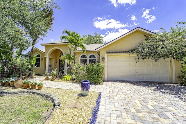 view of front of house featuring stucco siding, decorative driveway, and an attached garage