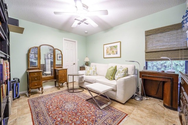 living room with ceiling fan and a textured ceiling