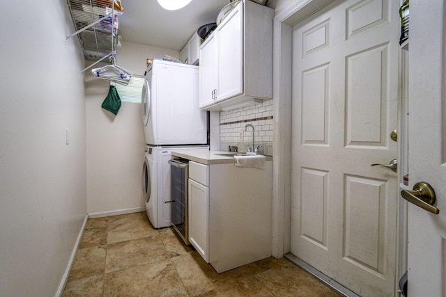 laundry area featuring estacked washer and dryer, cabinet space, and baseboards