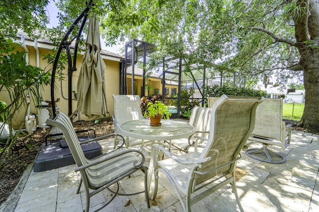 view of patio / terrace featuring outdoor dining space and glass enclosure