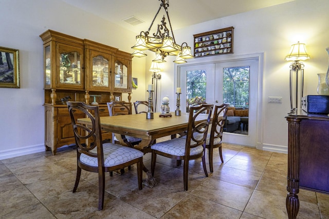 dining room featuring baseboards, french doors, and a chandelier