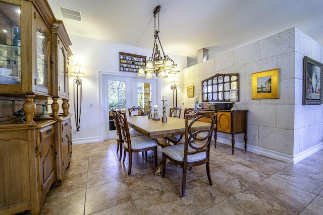 dining space featuring a chandelier and baseboards