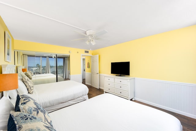 9800 S Ocean Dr Unit 415, Jensen Beach, FL 34957 - bedroom featuring wainscoting, dark wood-style floors, and a ceiling fan