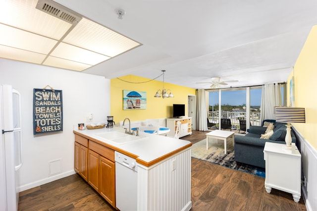 9800 S Ocean Dr Unit 415, Jensen Beach, FL 34957 - kitchen featuring a sink, white appliances, a peninsula, ceiling fan, and dark wood-style flooring