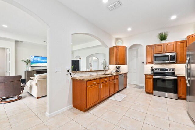 3552 SW Dellamano St, Port Saint Lucie, FL 34953 - kitchen featuring stainless steel appliances, a sink, decorative backsplash, light tile patterned flooring, and light stone countertops