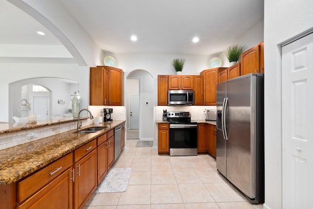 3552 SW Dellamano St, Port Saint Lucie, FL 34953 - kitchen featuring appliances with stainless steel finishes, a sink, stone countertops, backsplash, and brown cabinets
