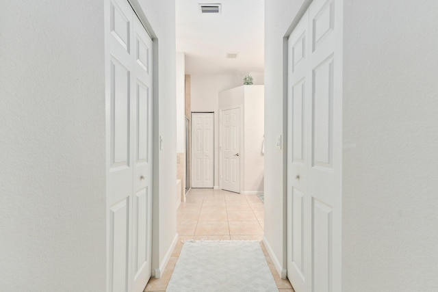 3552 SW Dellamano St, Port Saint Lucie, FL 34953 - corridor with light tile patterned flooring, a textured wall, and baseboards