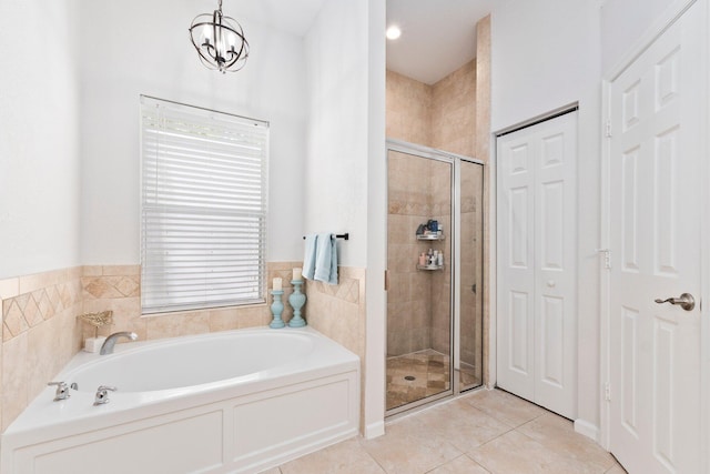 3552 SW Dellamano St, Port Saint Lucie, FL 34953 - full bathroom featuring a stall shower, a bath, tile patterned floors, a chandelier, and a closet