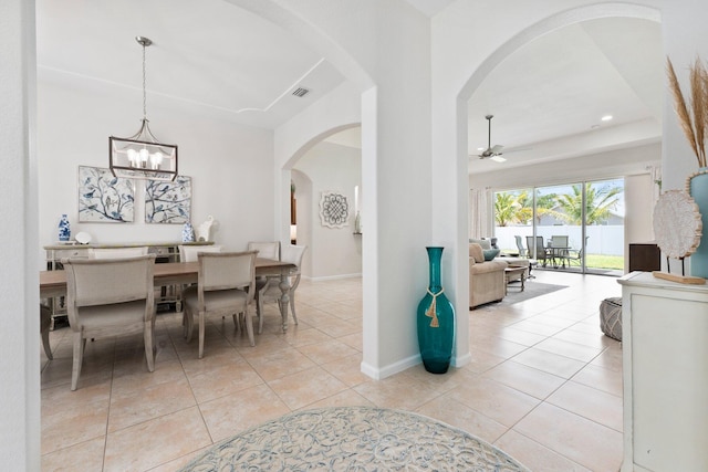 3552 SW Dellamano St, Port Saint Lucie, FL 34953 - dining room with arched walkways, a ceiling fan, light tile patterned floors, a chandelier, and baseboards