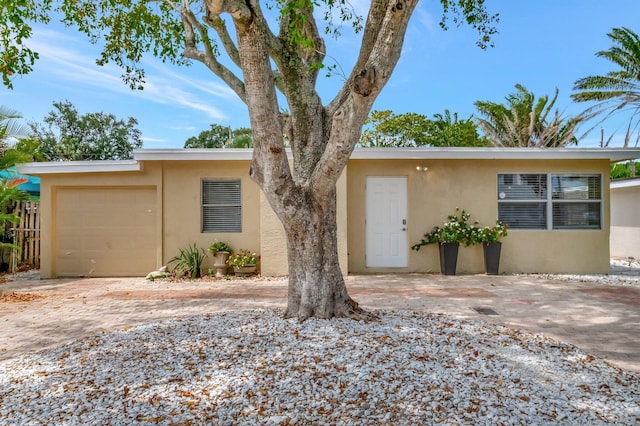 125 E Hart St, Lantana, FL 33462 - mid-century modern home featuring stucco siding, an attached garage, and driveway