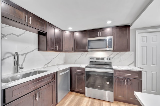 125 E Hart St, Lantana, FL 33462 - kitchen featuring appliances with stainless steel finishes, a sink, light wood-style floors, dark brown cabinets, and recessed lighting