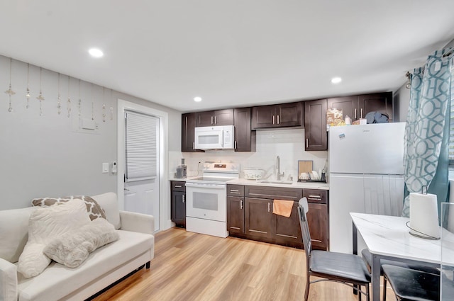 125 E Hart St, Lantana, FL 33462 - kitchen featuring white appliances, a sink, dark brown cabinets, light wood-style floors, and light countertops