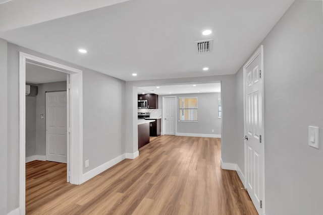 125 E Hart St, Lantana, FL 33462 - kitchen featuring stainless steel microwave, light wood finished floors, baseboards, dark brown cabinetry, and light countertops