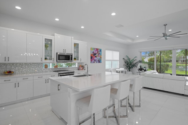 12582 Copper Mountain Pass, Boynton Beach, FL 33473 - kitchen featuring a sink, stainless steel appliances, decorative backsplash, open floor plan, and white cabinets