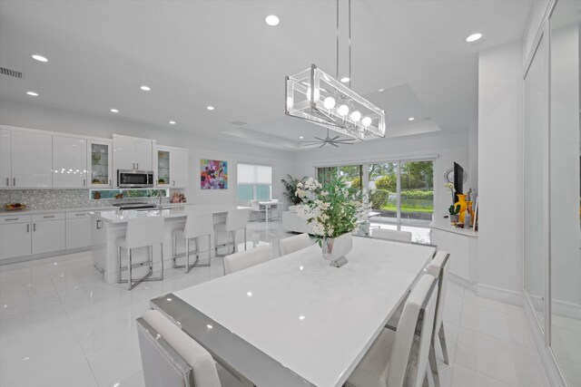 12582 Copper Mountain Pass, Boynton Beach, FL 33473 - dining space with a raised ceiling, recessed lighting, light tile patterned floors, baseboards, and a ceiling fan