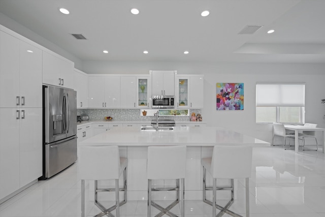 12582 Copper Mountain Pass, Boynton Beach, FL 33473 - kitchen with stainless steel appliances, recessed lighting, light countertops, a breakfast bar, and white cabinetry