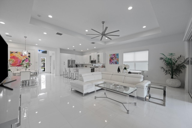12582 Copper Mountain Pass, Boynton Beach, FL 33473 - living room with a tray ceiling, light tile patterned floors, ceiling fan, and recessed lighting