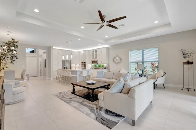 12685 New Caladonia Ln, Boynton Beach, FL 33473 - living room featuring a raised ceiling, ceiling fan, recessed lighting, light tile patterned floors, and baseboards
