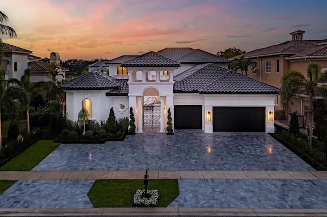 17709 Circle Pond Ct, Boca Raton, FL 33496 - mediterranean / spanish home featuring an attached garage, stucco siding, a tile roof, and decorative driveway