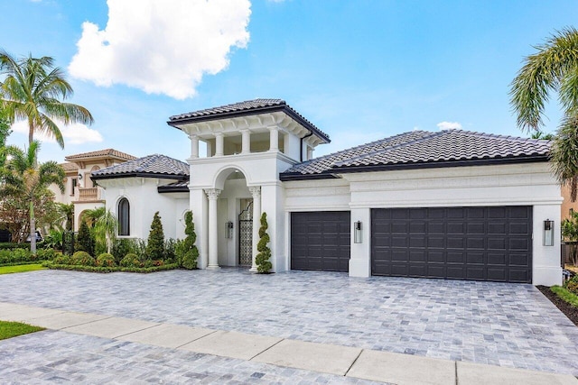 17709 Circle Pond Ct, Boca Raton, FL 33496 - mediterranean / spanish-style house with an attached garage, a tiled roof, stucco siding, and decorative driveway