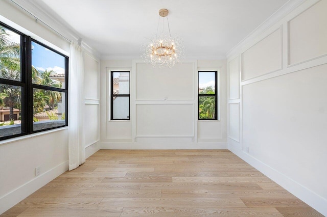17709 Circle Pond Ct, Boca Raton, FL 33496 - unfurnished dining area featuring a chandelier, plenty of natural light, a decorative wall, light wood finished floors, and ornamental molding