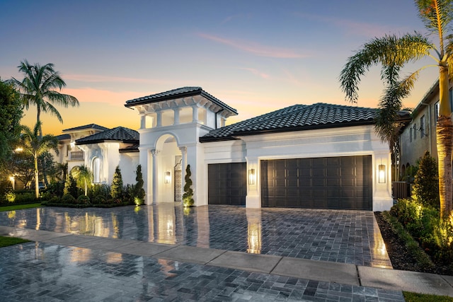 17709 Circle Pond Ct, Boca Raton, FL 33496 - mediterranean / spanish-style home with an attached garage, decorative driveway, a tiled roof, and stucco siding