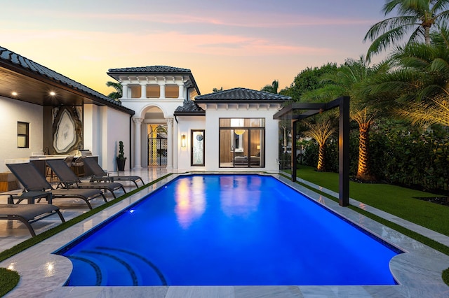 17709 Circle Pond Ct, Boca Raton, FL 33496 - back of house at dusk with a tile roof, stucco siding, a patio, and an outdoor pool