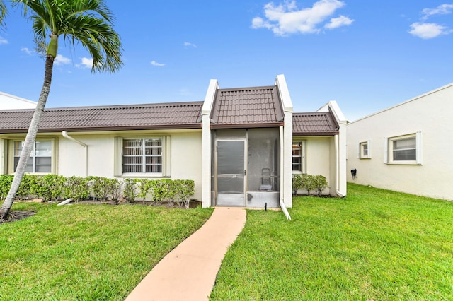 109 Lake Rebecca Dr Unit 109, West Palm Beach, FL 33411 - back of house with a tiled roof, stucco siding, a lawn, and a sunroom