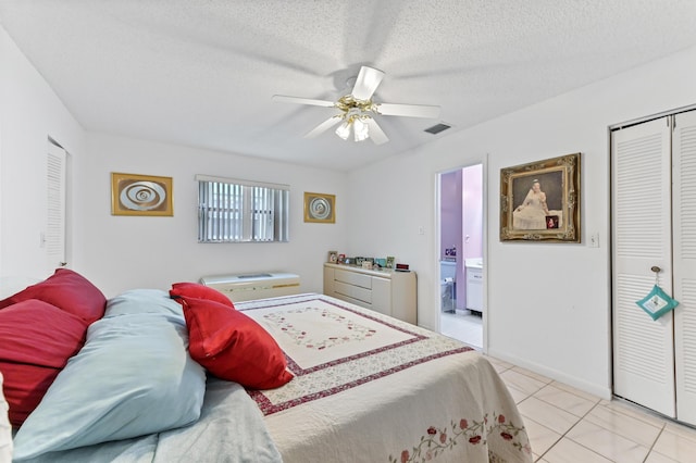 109 Lake Rebecca Dr Unit 109, West Palm Beach, FL 33411 - bedroom featuring light tile patterned floors, ceiling fan, a closet, ensuite bath, and a textured ceiling