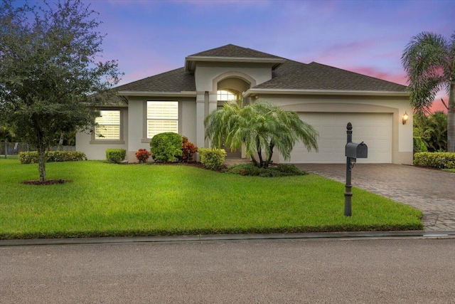 8369 Paladin Sq, Vero Beach, FL 32967 - view of front facade featuring decorative driveway, an attached garage, stucco siding, a front yard, and a shingled roof